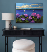 Impasto palette knife painting artwork of fuchsia hydrangeas and sailboats on a blue wall above a black console table.