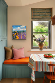 Nook with a window, colorful tablecloth, and painting of a lavender field.