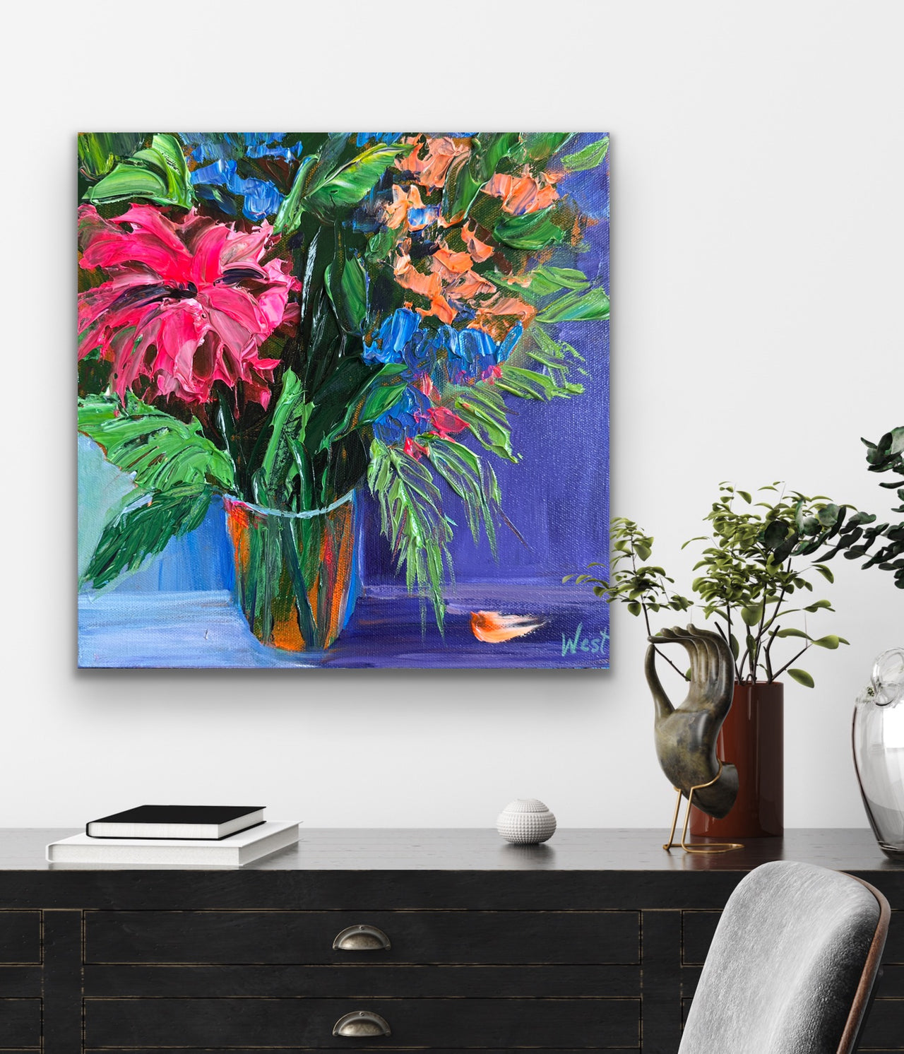 Colorful palette knife impasto floral painting on a wall above a desk with decorative items.