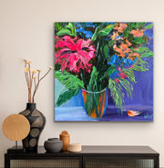 Colorful floral palette knife impasto painting on a wall above a console table with decorative items.