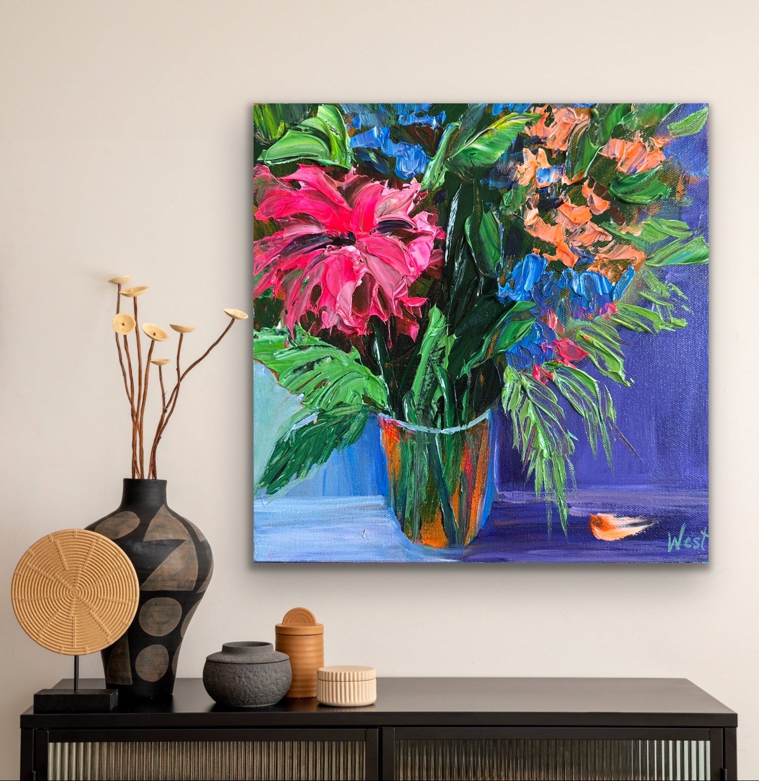 Colorful floral palette knife impasto painting on a wall above a console table with decorative items.