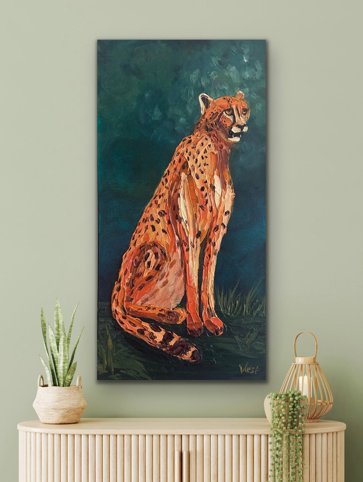 Painting of a cheetah on a wall above a cabinet with decorative items.