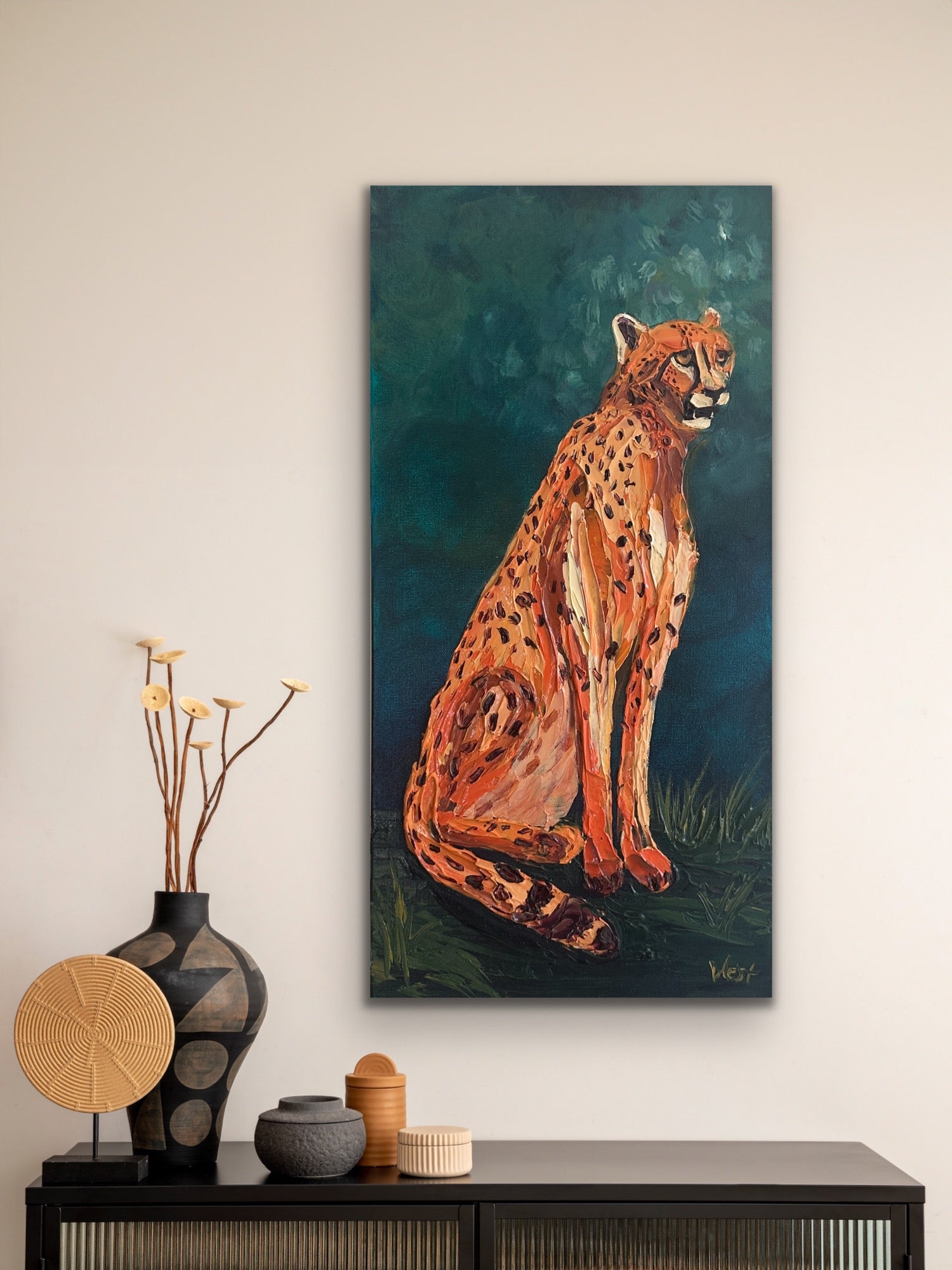 Painting of a cheetah on a wall above a console table with decorative items.