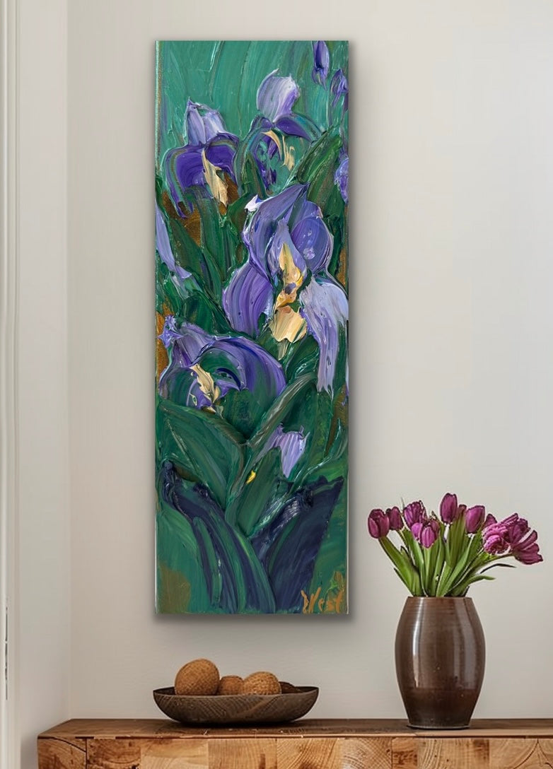 Impasto palette knife painting of purple flowers on a wall above a wooden console table with a vase of tulips.