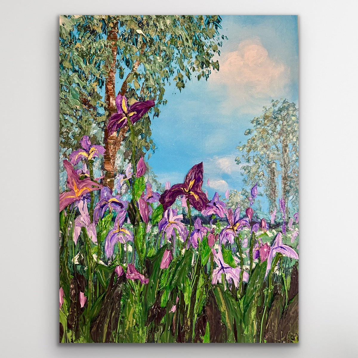 Painting of purple irises  with a blue sky and green trees.