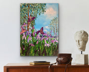 Painting of irises on a wall above a wooden cabinet with a camera and sculpture.