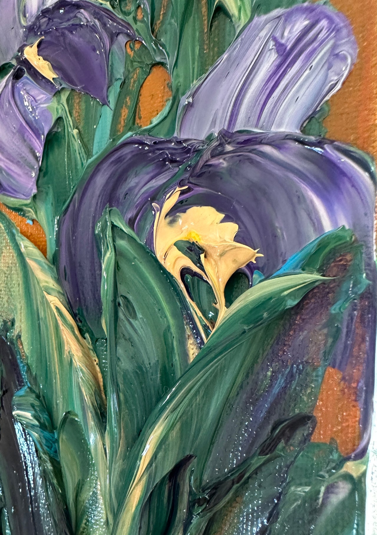 Close-up of a palette knife impasto painting of purple irises and green leaves with a textured background.