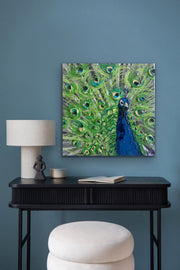 Peacock painting on a wall above a black console table with decor items.