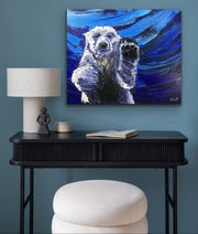 Painting of a polar bear holding a paw on a blue wall above a black console table.