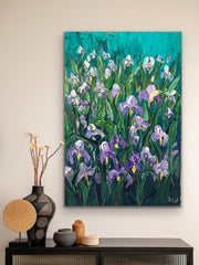 Palette knife impasto painting of irises on a wall above a console table with decorative items.