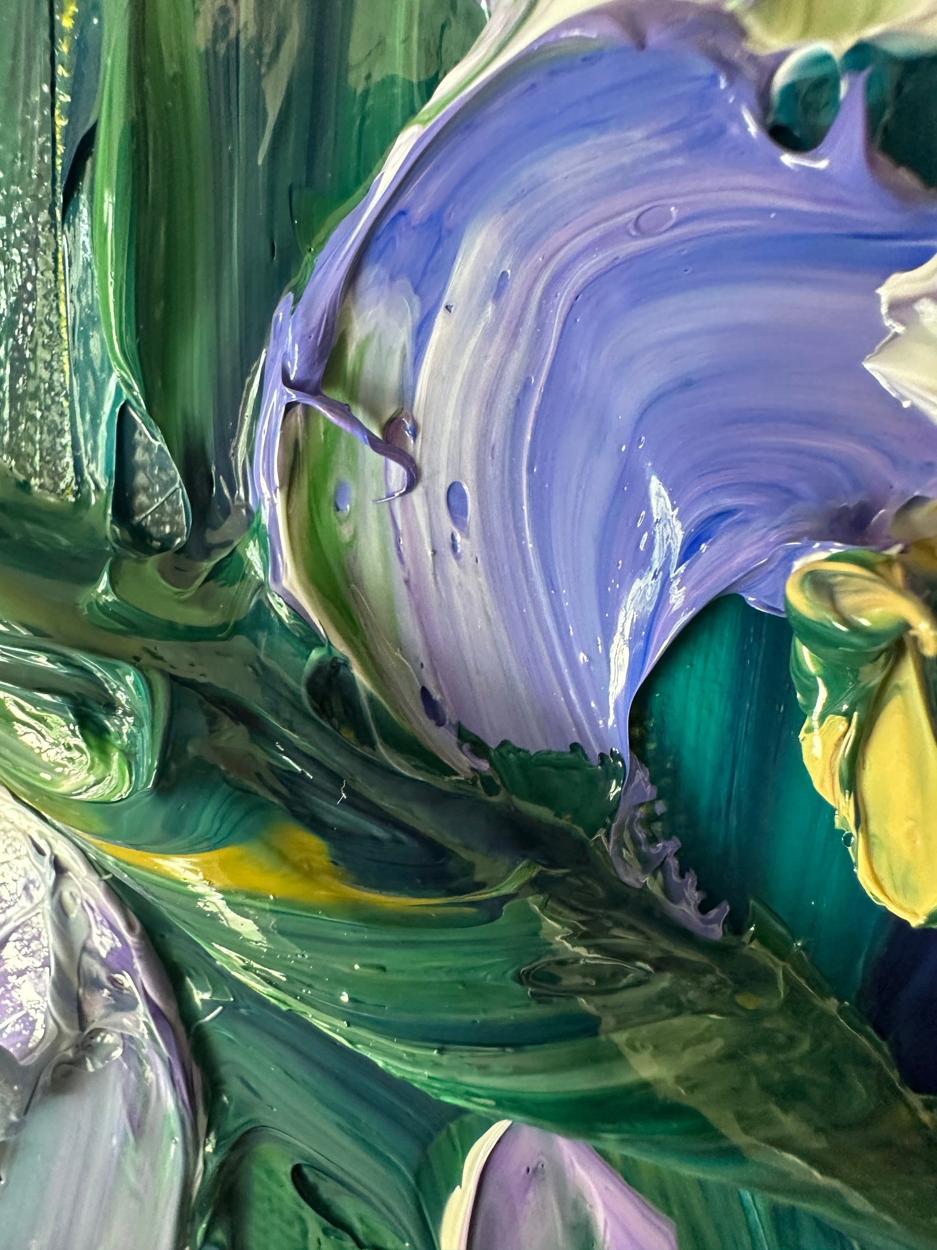 Close-up of a palette knife impasto painting swirling paint colors in green, purple, and yellow.