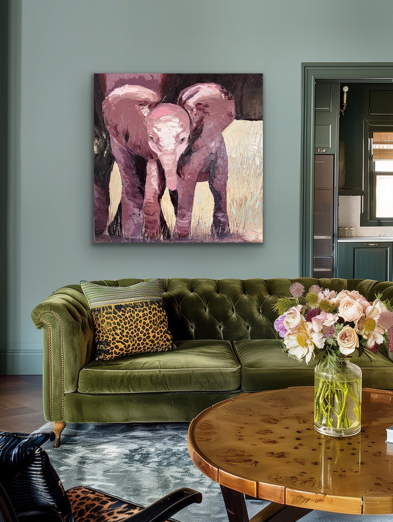 Living room with green sofa, round wooden table, and abstract elephant painting on wall.