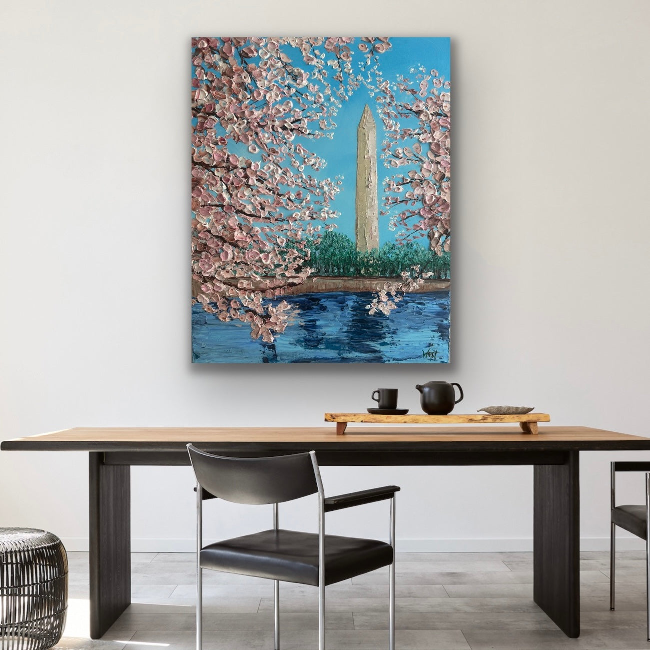 Dining room with a large painting of cherry blossoms and the Washington Monument above a wooden table.