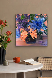 Floral palette knife painting on a wall above a table with a book and mug.
